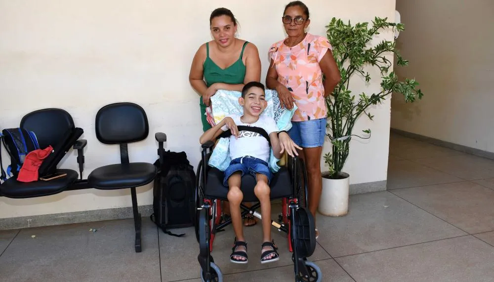 Gabriel e sua família após receberem a nova cadeira de rodas