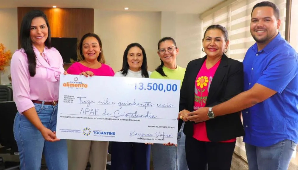 Equipe da Apae de Cristalândia recebe o cheque simbólico das mãos da primeira-dama Karynne Sotero.