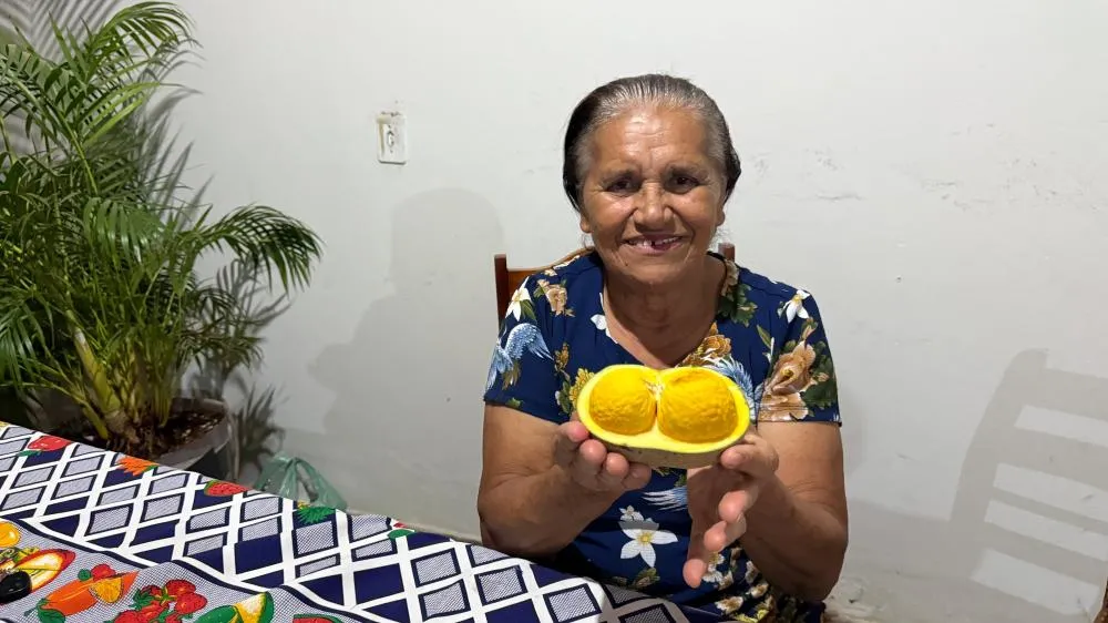 Presidente Aldenora Martins dos Santos apresentando o fruto do pequi.
